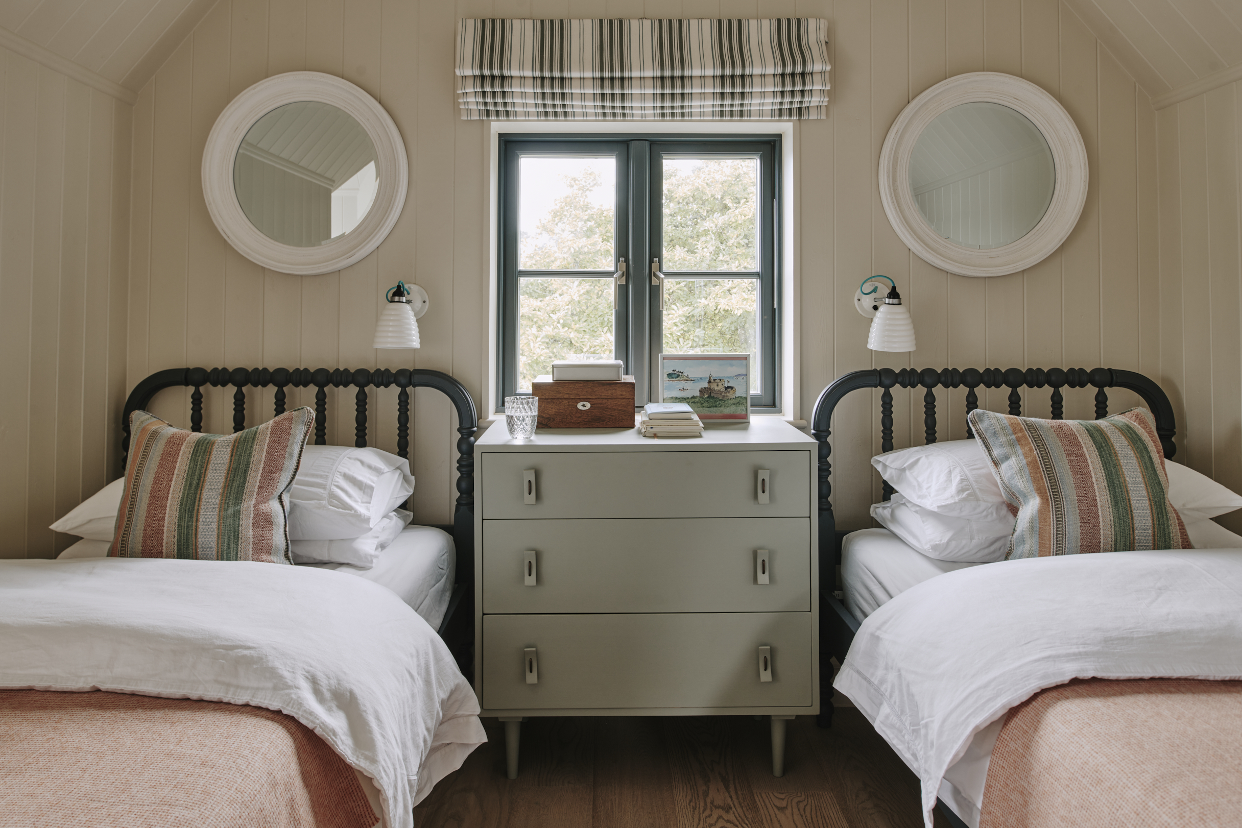 Twin bedroom with porthole mirrors